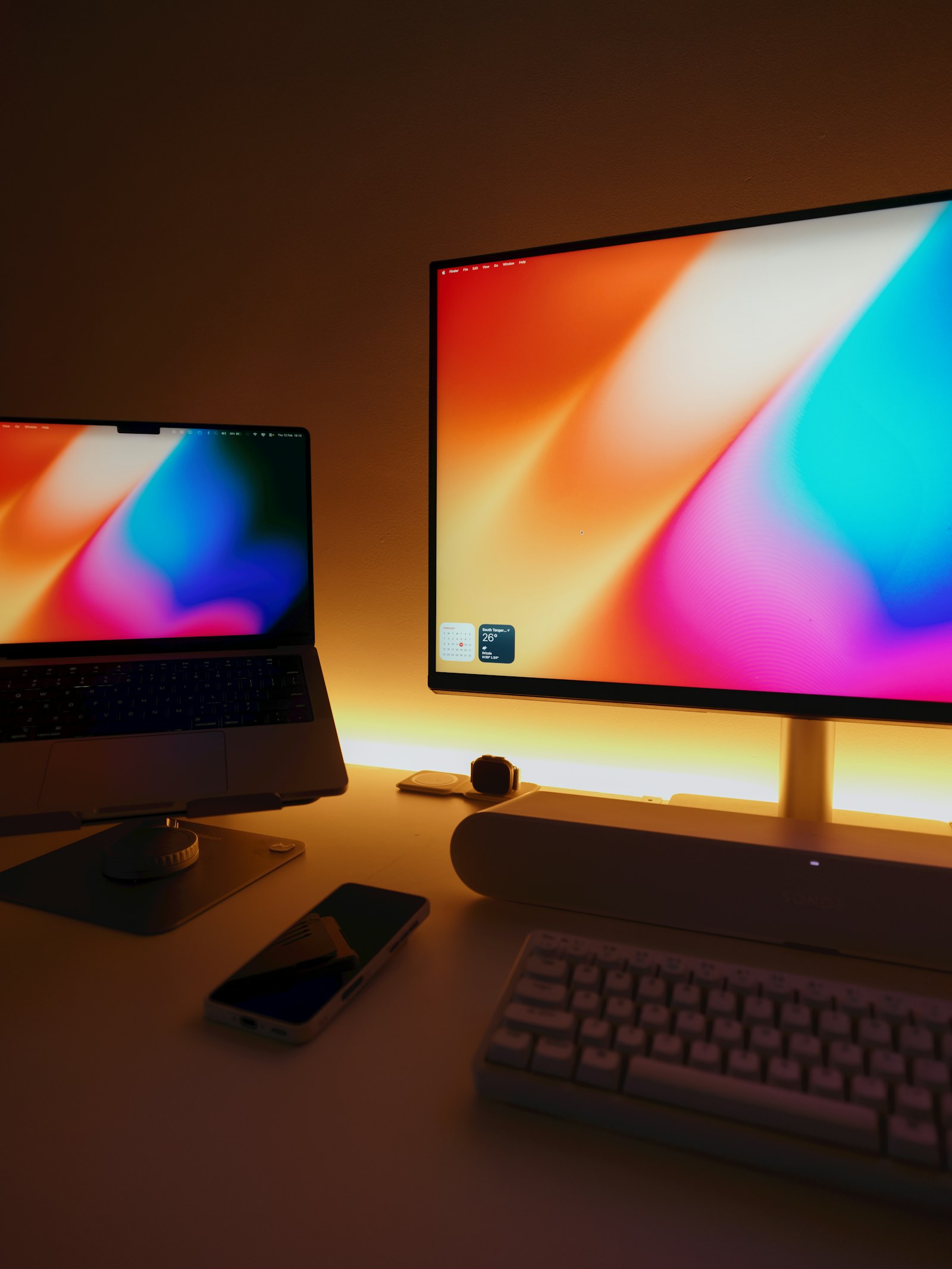 Postazione con MacBook, monitor e smartphone configurati insieme